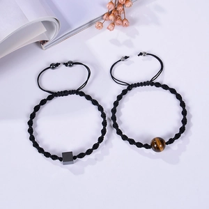 Macro detail of adjustable woven bracelets with tiger eye stones and black square beads