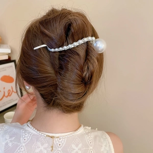 Macro detail of geometric pearl hair clip styled in a French twist hairstyle