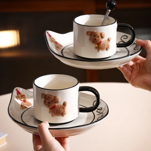Detail of two cute ceramic coffee mugs and saucers featuring hand-painted 3D dogs