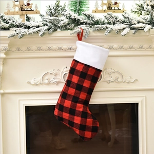 Classic red and black buffalo plaid Christmas stocking with white faux fur cuff on fireplace