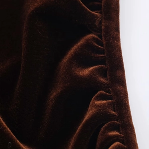 Gros plan détaillé du tissu en velours marron foncé avec plis élégants et coutures