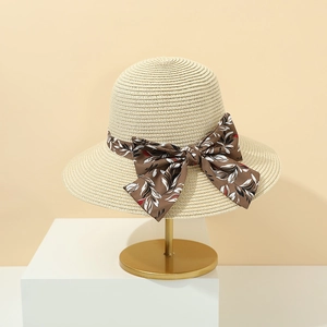 Elegante cappello di paglia da donna con fiocco floreale marrone su una base dorata