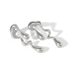 Détail de boucles d'oreilles irrégulières en métal liquide argenté sur fond blanc épuré