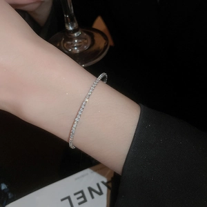 Detail shot of a minimalist silver tennis bracelet with cubic zirconia on a wrist