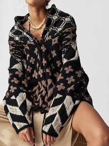 Close-up of thick knit cardigan texture and ethnic geometric patterns in black and brown