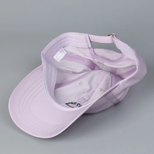 Inside view of lavender quick-dry baseball cap showing wash labels and sweatband