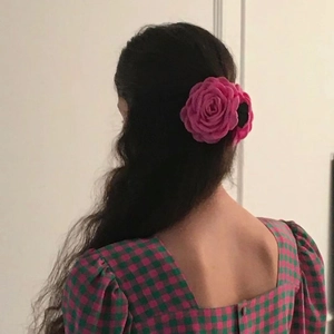 Detailed view of dusty rose fabric flower hair claw clip on brunette hair