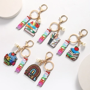 Teacher appreciation keychains set with ABC books, apple, and rainbow charms in gold finish