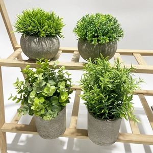 Close-up of four artificial potted green plants in grey textured pots on a wooden stand