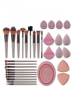 Detailed 33-piece champagne gold makeup brush set with pink beauty sponges and silicone cleaner