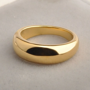Polished 18K gold-plated minimalist dome ring displayed on a soft grey jewelry pad