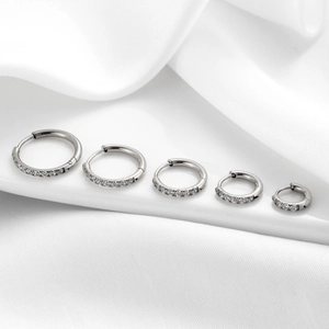 Set of 5 silver stainless steel hoop earrings with sparkling cubic zirconia on white silk