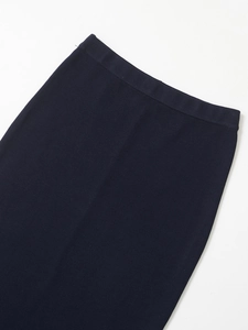 Close-up of navy blue knit texture and elastic waistband on a satin midi skirt