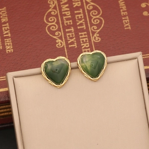 Elegant gold-trimmed heart stud earrings with deep green stones in Maillard style