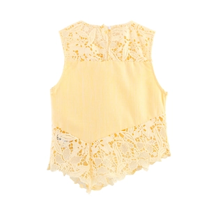 Close-up of yellow sleeveless top featuring floral lace patchwork and button detail