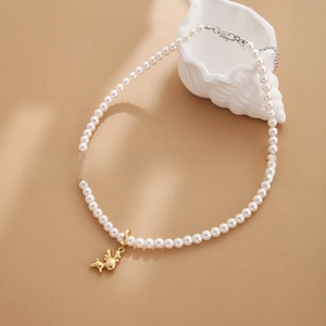 Detail of 18k gold-plated rabbit pendant on white pearl necklace with adjustable clasp