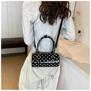 Detailed close-up of glossy polka dot Boston bag with silver zipper and D-ring