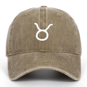 Close-up detail of Taurus zodiac embroidery on washed khaki cotton baseball cap