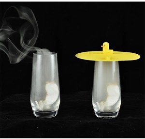 Yellow silicone drain cover with duck handle showing steam containment on a glass cup