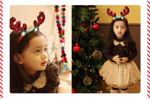 Close-up of sequined red reindeer antlers headband for kids with festive Christmas tree