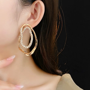 Close-up of gold-plated double hoop earrings featuring pavé rhinestones on model