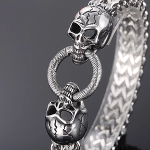 Macro detail of gothic skull bracelet with snake texture ring and V-shape chain link