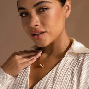 Gold interlocking circle necklace with opal inlay detail worn by a fashion model
