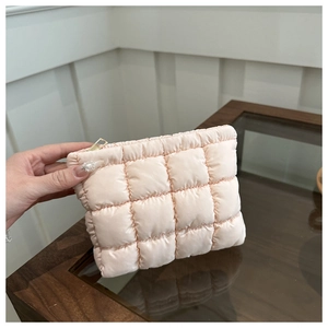 Close-up of light pink quilted nylon handbag with premium gold zipper detail