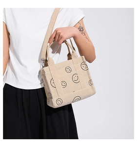 Dettaglio della borsa tote in velluto a coste bianco crema con stampa smile nera