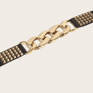 Close-up of elastic waist belt with gold chunky chain and metallic pyramid studs detail