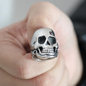 Macro di anello con teschio in argento su dito maschile con dettagli in stile gotico punk