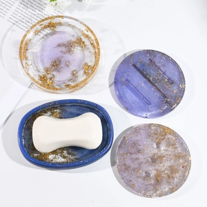 Detail view of oval resin soap dishes with embedded gold foil flakes in galaxy colors