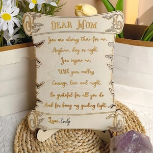 Detail of wooden Mother's Day scroll plaque with engraved poem on a rustic table