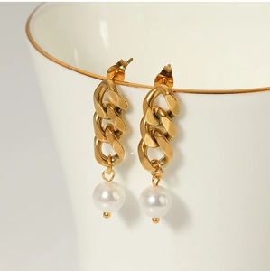 Close-up of 18K gold stainless steel chain earrings with pearls on a ceramic cup