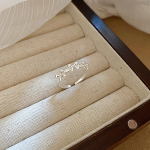 Detail of silver bow ring with rhinestones and pearls displayed in a jewelry box
