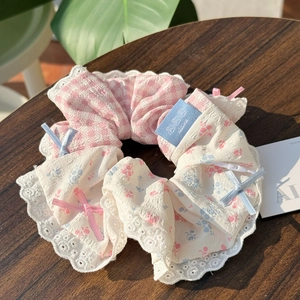 Close-up of pink plaid and blue floral scrunchie with lace trim and ribbon bows