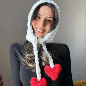 Detailed knit texture of white Balaclava with red heart charms and long straps