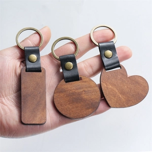Detailed close-up of walnut wood keychains in heart, round and rectangle shapes