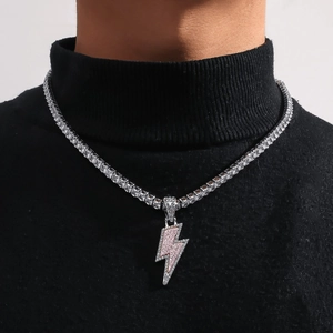 Detail of pink and white crystal lightning pendant on silver tennis chain over black sweater