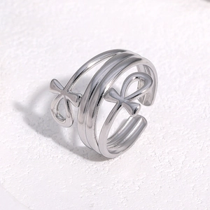 Macro view of silver Ankh symbol open ring on a textured white plaster background