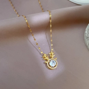 Macro shot of gold deer antler necklace with zircon stones on soft pink satin fabric