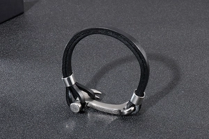 Detail of multi-layer black braided leather bracelet with brushed stainless steel clasp