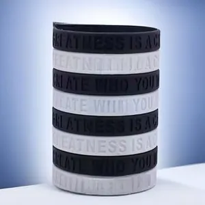 Detail of engraved black and white silicone wristbands featuring inspirational phrases
