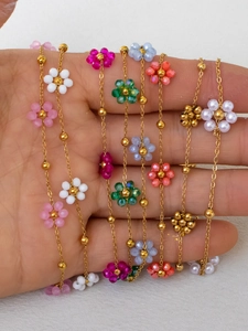 Detail of colorful beaded flower charms on elegant gold stainless steel chains