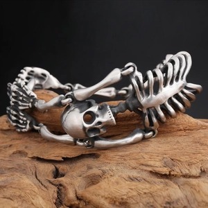 Macro detail of gothic skull skeleton bracelet in antique silver on wooden background