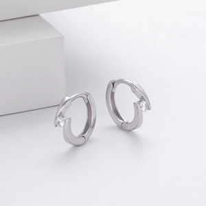 Macro detail of 925 sterling silver hoop earrings with clear round cubic zirconia