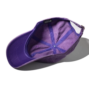Detailed interior of purple cotton baseball cap showing seams and 100% cotton label