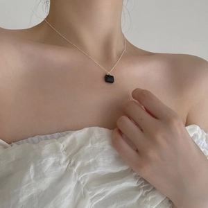 Close-up of a 925 sterling silver necklace with a mini black zircon padlock pendant