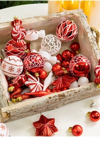Detail of red and white Christmas ornaments with glitter patterns on a wooden tray