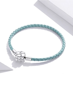 Close-up of woven blue leather bracelet with silver flower push-clasp closure